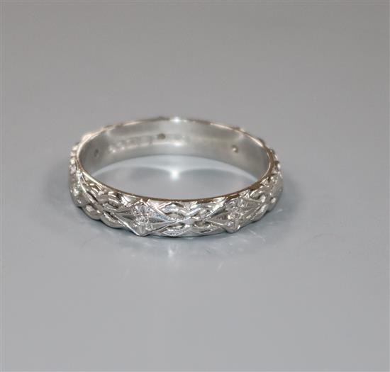 A modern carved 18ct white gold and diamond set eternity ring, size V/W.